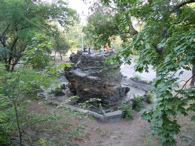 Великий камінь у парку з людьми зверху