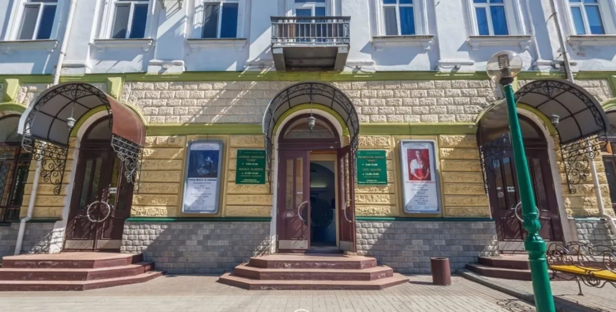 Фасад будівлі з арками та афішами